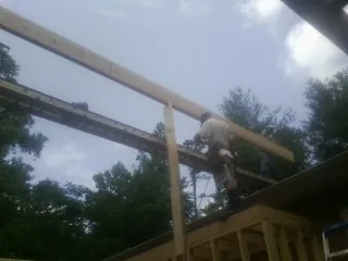 Carpenter setting a ridge beam over a new addition frame — Ice Dam Removal by Roofing Brothers in Fair Lawn