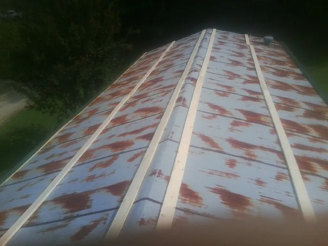 Rusted metal roof panels with new wood purlins before replacement — Storm Damage Roof Repair in Fair Lawn by Roofing Brothers