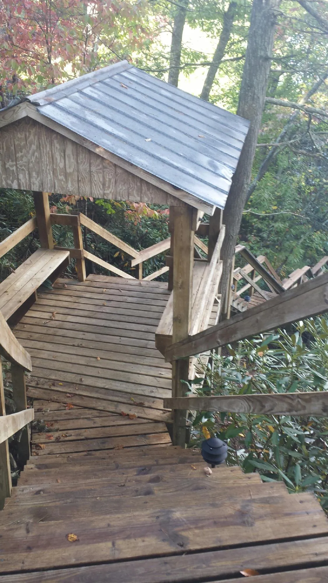 Metal roofed shelter over wooden steps on a wooded walkway — Skylight Repair & Installation work by our crew in Fair Lawn
