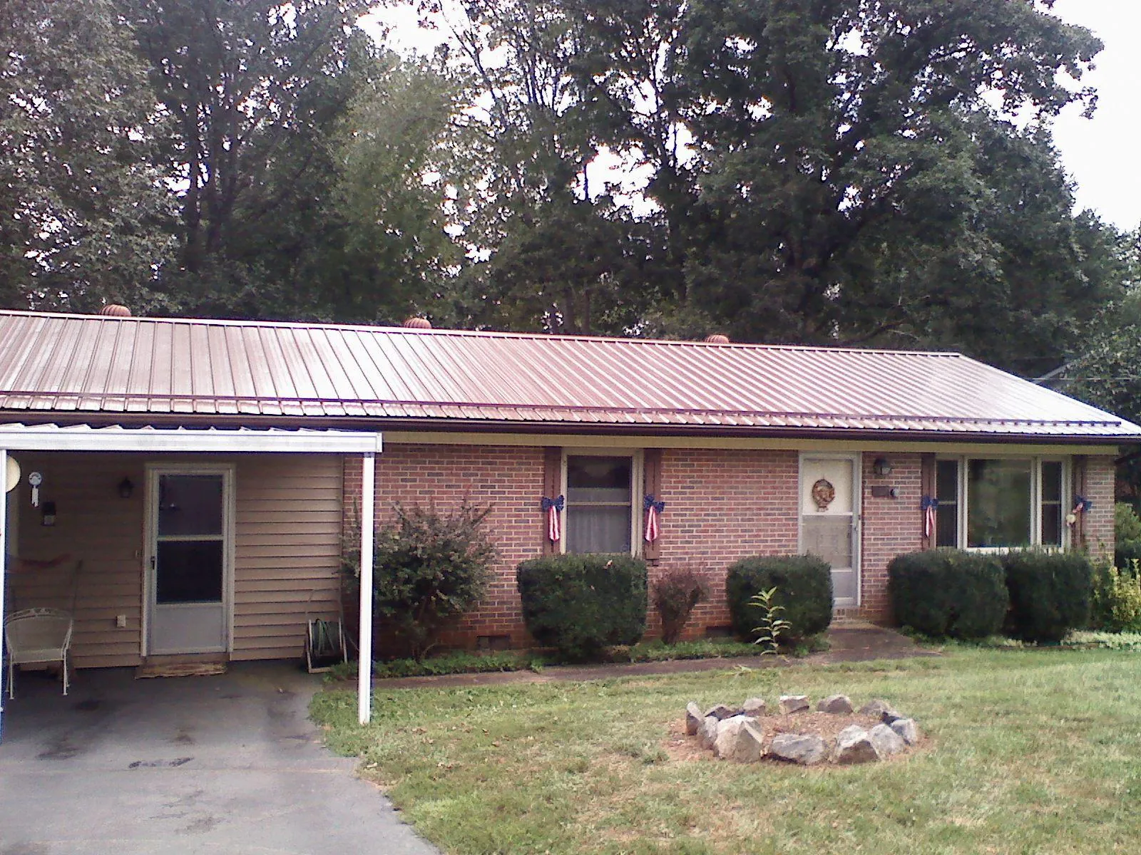 Bronze metal roof and carport on a brick ranch home — Roof Repair work by our crew in Fair Lawn